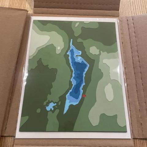 cut paper artwork of a small pond with topography