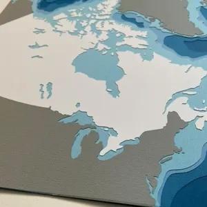 cut paper artwork showing Canada in white with surrounding countries in grey