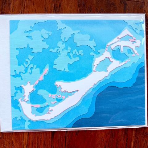 Bermuda papercut art with "pink sand" layer in packaging.